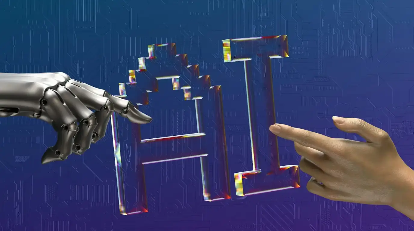 A robotic hand and a human hand reaching toward faceted glass letters reading AI.